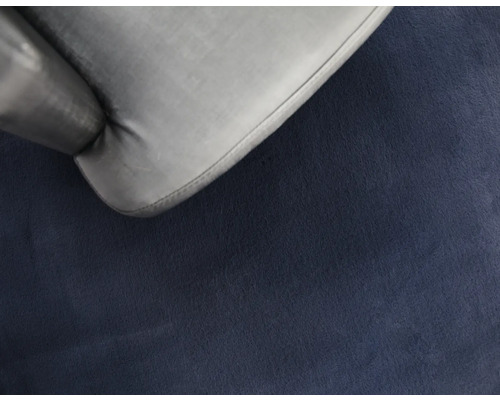 Detailaufnahme eines grauen Stuhls auf einem blauen Teppich