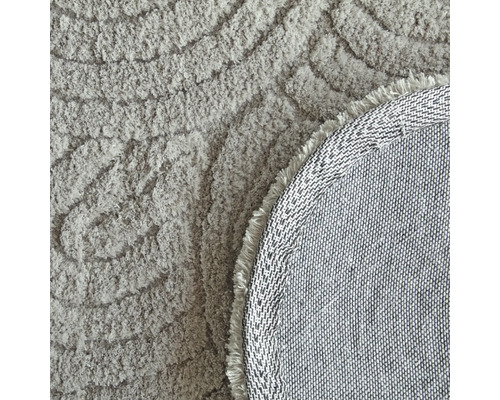 Detailansicht eines runden Teppichs mit Muster und Fransen