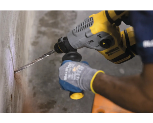 Ein Mann bohrt mit einem Bohrhammer ein Loch in eine Wand.