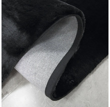 Detailansicht eines schwarzen Teppichs mit Textilrückseite