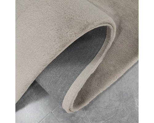 Nahaufnahme eines beigen Teppichs mit gekräuselter Kante