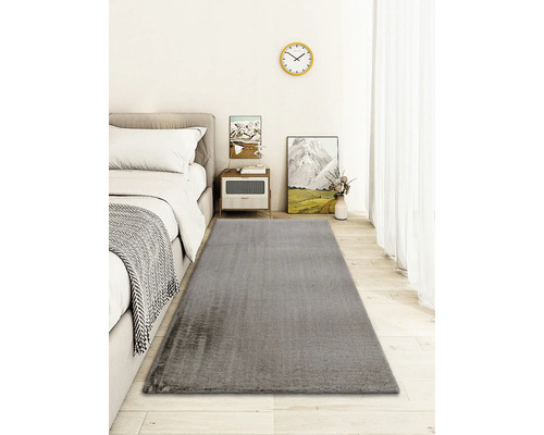 Grauer Teppich in einem Schlafzimmer mit Bett und Beistelltisch