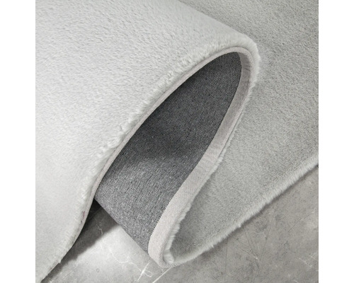 Detailansicht eines hellen Teppichs mit Textilrücken