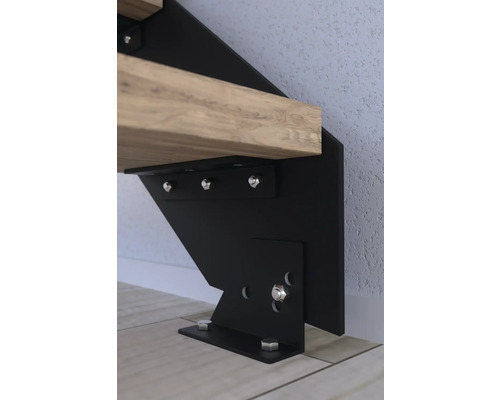 Detail einer Treppenwange mit Holzstufe und Schraubenbefestigung.