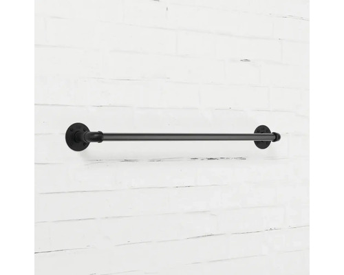 Schwarze Handtuchstange aus Metall an einer Ziegelwand