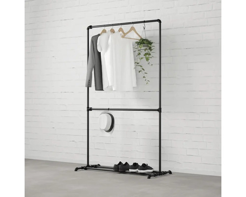 Schwarzer Kleiderständer aus Metall mit Kleidung, Hut, Schuhen und einer Pflanze