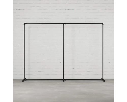 Doppelter Kleiderständer aus Rohren vor einer Ziegelwand