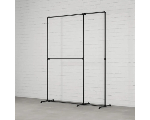 Kleiderständer aus Rohren vor einer Backsteinwand