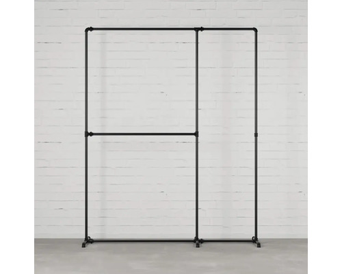 Kleiderständer aus Metallrohren vor einer weißen Ziegelwand