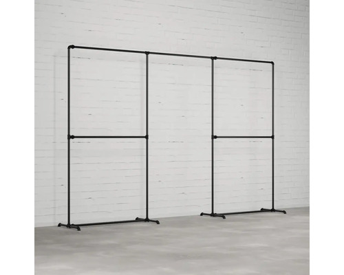 Garderobenständer aus Stahlrohr im Industriedesign vor einer weißen Ziegelwand.