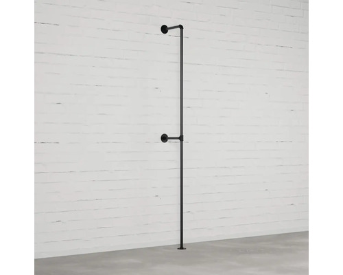 Schwarze Kleiderstange aus Rohren an einer Wand montiert