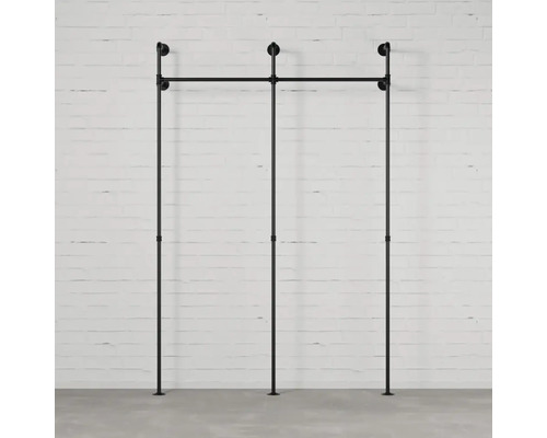 Schwarzes modulares Regalsystem vor einer Backsteinmauer