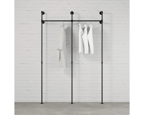 Schwarzer Kleiderständer aus Rohren mit Kleidung an einer Wand