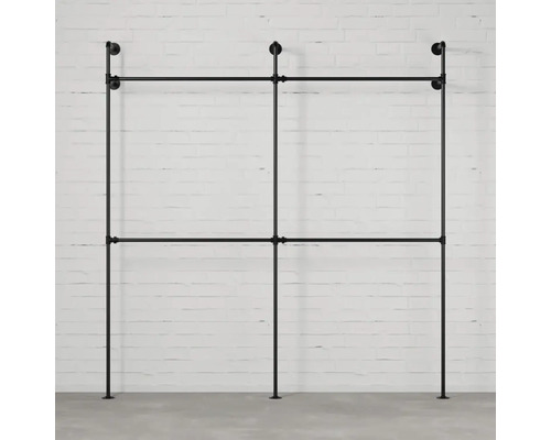 Freistehende Kleiderstange aus Metallrohren vor einer Wand