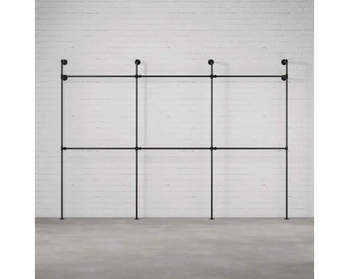 Schwarzes Rohr-Kleiderständer-System vor einer Ziegelwand