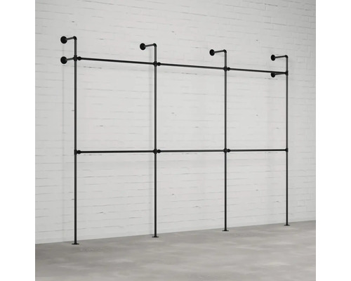 Schwarzes Kleiderstangensystem aus Stahlrohr vor einer Backsteinmauer