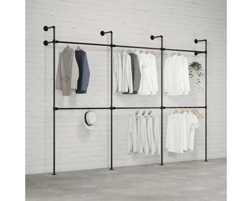 Freistehende Kleiderständeranlage mit mehreren Kleidungsstücken, Hut und Pflanze