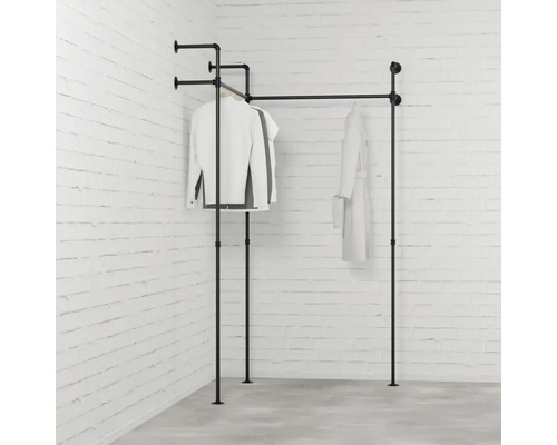 Kleiderständer aus Metallrohren mit aufgehängter Kleidung vor einer Backsteinwand