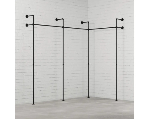 Kleiderständer aus Rohren im Eckzimmer vor einer Backsteinmauer