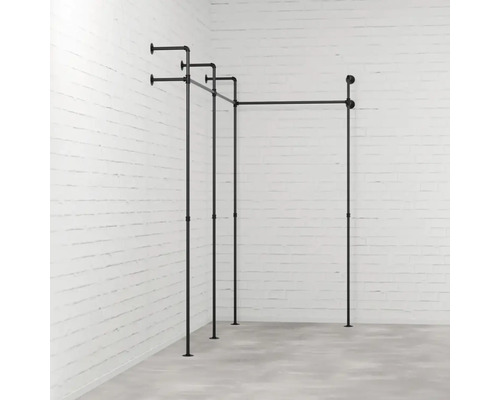 Schwarze Kleiderständer-Konstruktion aus Rohren vor einer Backsteinwand