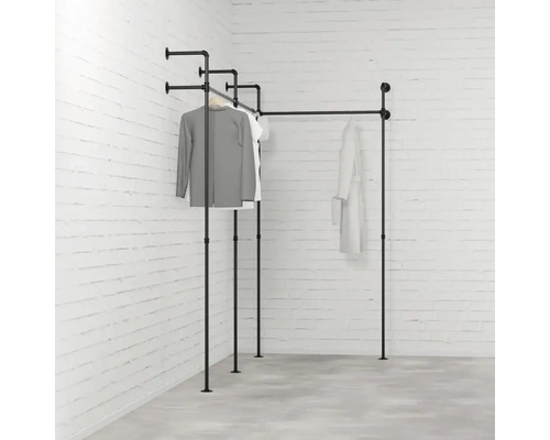 Schwarze Kleiderstange aus Metallrohr im Eckzimmer mit Kleidung