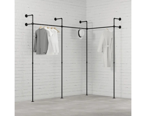 Eckkleiderständer aus Rohren mit Kleidung vor einer Backsteinwand