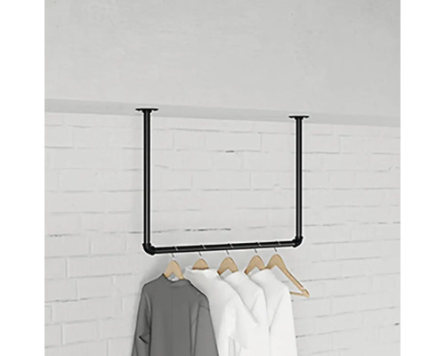 Kleiderständer aus Stahlrohr mit daran hängenden Kleidungsstücken vor einer Ziegelwand