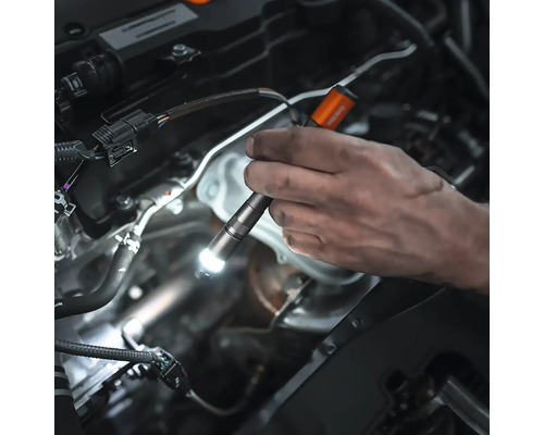 Eine Hand hält eine LED-Inspektionslampe zur Inspektion eines Automotors.