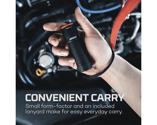 Eine Person hält eine kleine, schwarze Taschenlampe mit einem Trageband vor einem Automotor.