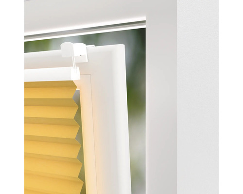 Detailansicht eines gelben Plissees am Fenster