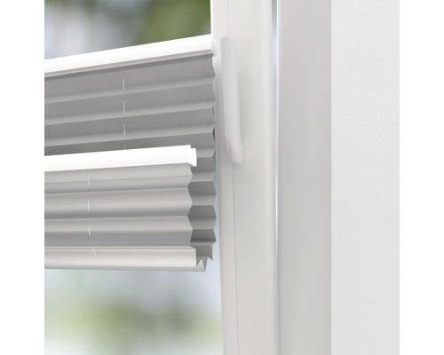 Nahaufnahme einer weißen Plisseejalousie an einem Fenster