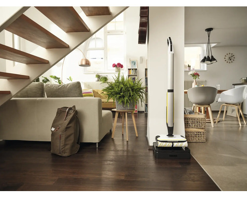 Helles Wohnzimmer mit Treppe, Sofa, Zimmerpflanze, Rucksack und Akku-Wischmopp