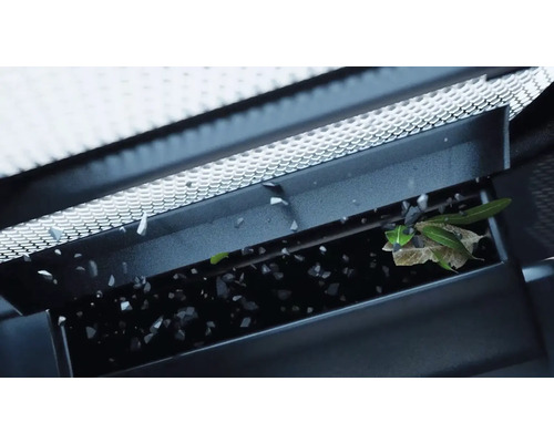 Dachrinnenreinigung mit fallenden Blättern und Schmutzpartikeln