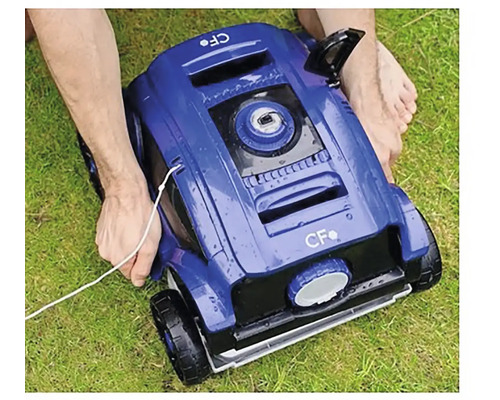 Blauer Poolreinigungsroboter wird auf Gras platziert