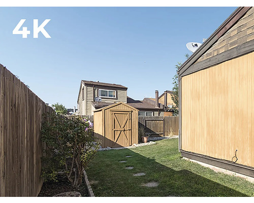 Ein Garten mit einem Holzschuppen und einem Holzzaun