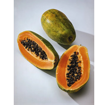 Ganze und halbe Papaya mit Kernen