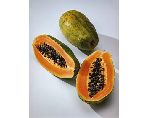 Ganze und halbe Papaya mit Kernen