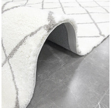 Weißer Teppich mit geometrischem Muster und hochflorigem Flor