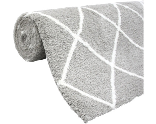 Grauer Teppich mit Rautenmuster aufgerollt