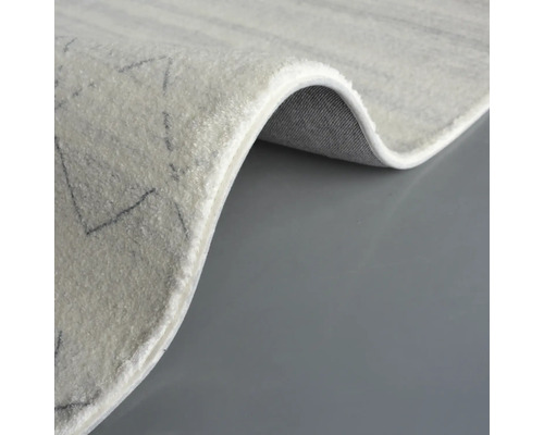 Detailansicht eines hellen Teppichs mit geometrischem Muster