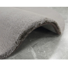 Detailansicht eines runden, grauen Teppichs mit hochflorigem Flor