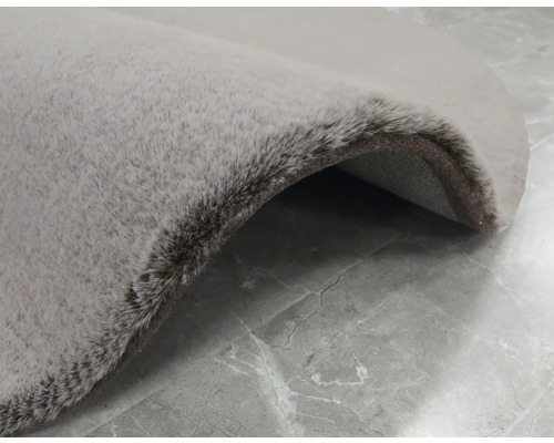 Detailansicht eines runden, grauen Teppichs mit hochflorigem Flor