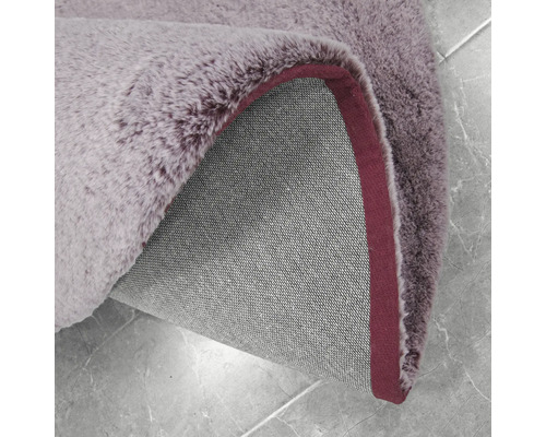 Detailansicht eines lilafarbenen Teppichs mit Flor und Textilrücken