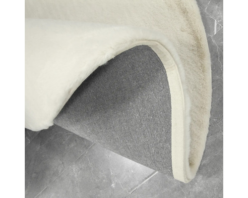 Detailansicht eines runden Teppichs mit Flor und gewebter Rückseite