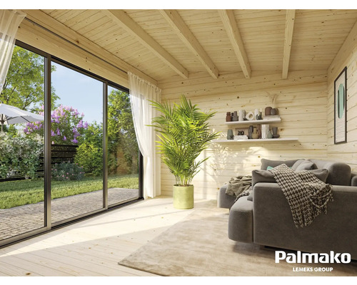 Helles Blockhausinterieur mit Sofa, Zimmerpflanze und Blick in den Garten durch eine große Fensterfront