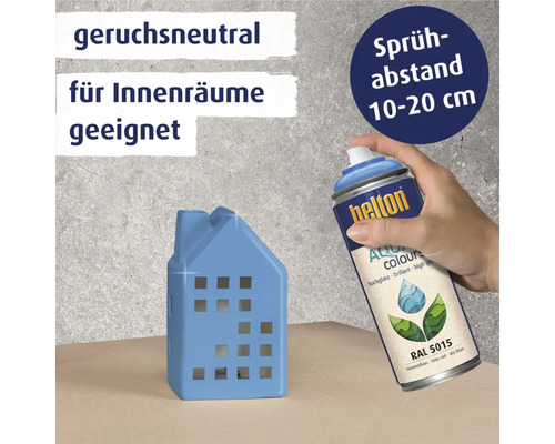Dekorationsobjekt in Hausform wird mit Farbspraydose behandelt