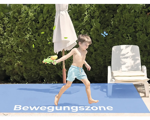 Junge spielt mit Wasserpistole im Bewegungsbereich im Freien
