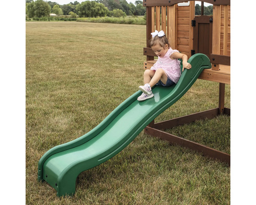 Mädchen rutscht auf einer grünen Kinderrutsche