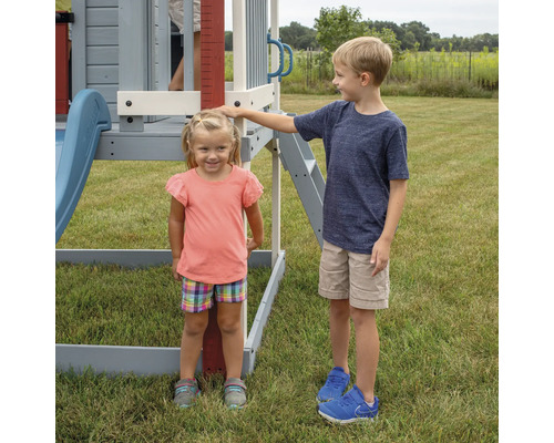 Zwei Kinder an einem Spielplatzgerät im Garten