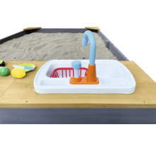 Detailansicht eines Sandkastens mit Spielküchenspüle und Spielzeug